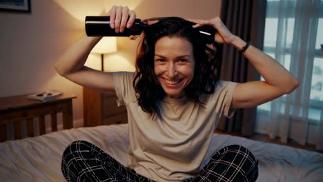 woman applying hair spray in bed