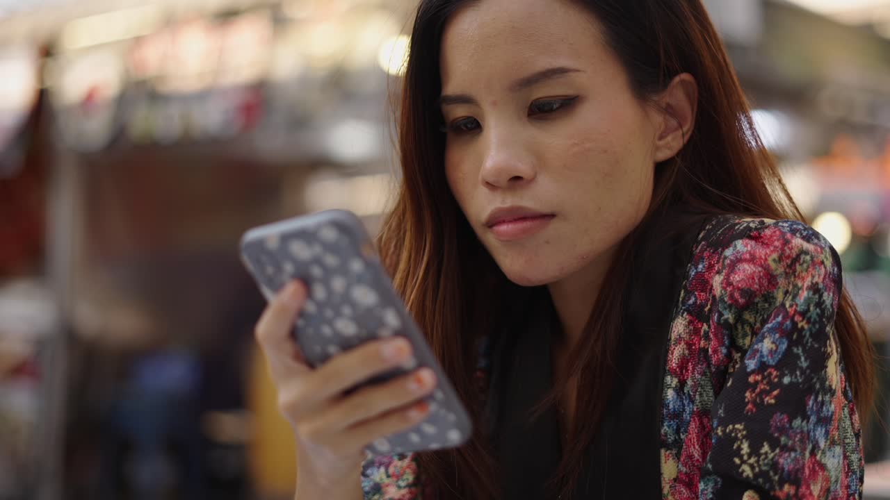 Young woman using her smartphone in an outdoor public setting
