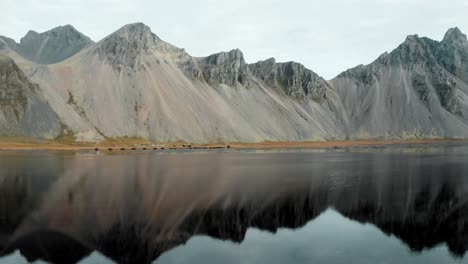 reflejo de la escarpada montaña vestrahorn en la playa húmeda de arena negra stokksnes en islandia