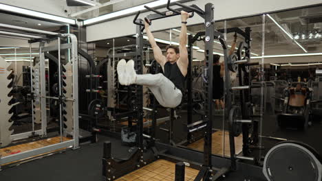 sporty australian sportsman doing hanging leg raises in gym