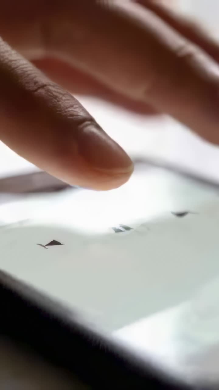Vertical video: Pressing finger on pause icon sliding right on desk screen lifting to control media