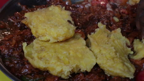 african black people eating with hands a sharing the same traditional tasty food dish from uganda with rice fritter and baker beans