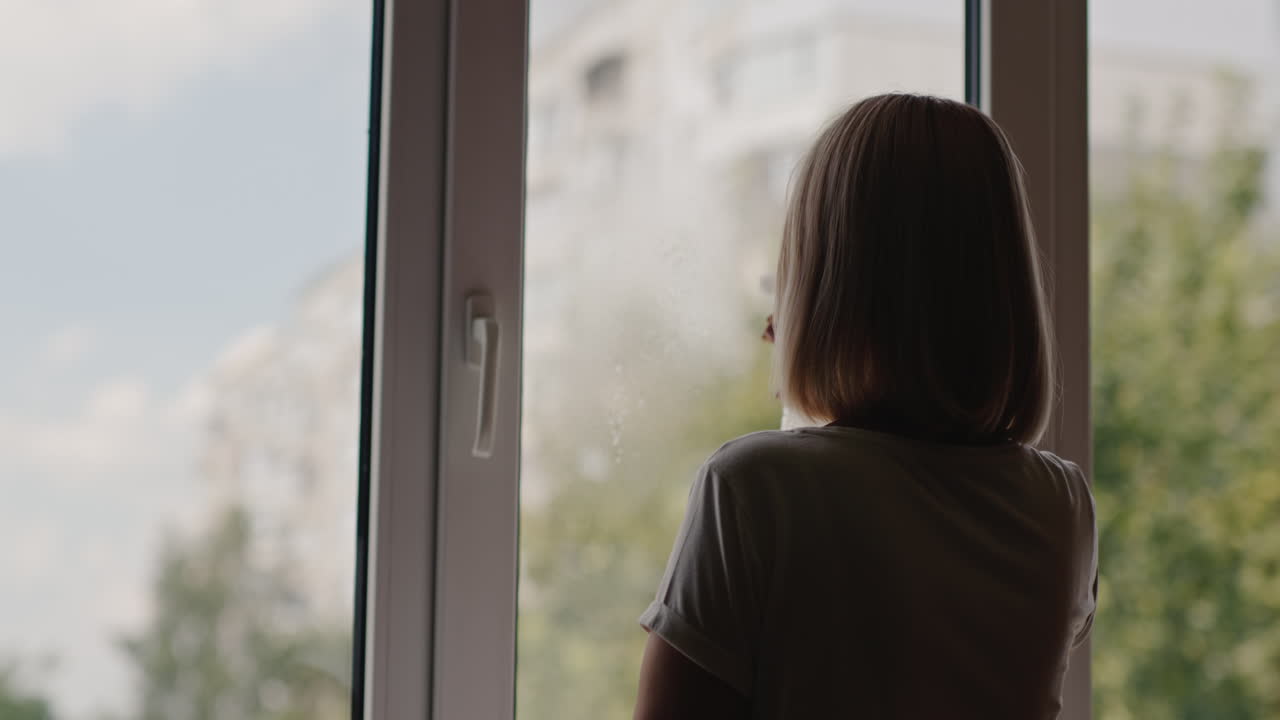 una mujer lava una ventana en el apartamento de un edificio alto 5