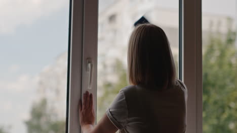 una mujer lava una ventana en el apartamento de un edificio alto 5