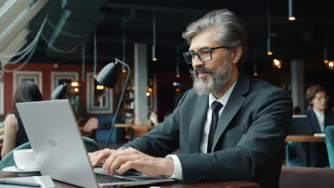 businessman working on laptop in a cafe