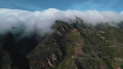 Beautiful-Aerial-Panning-View-of-Clouds-Rolling-Off-Mountains-in-Spain,-Dusk