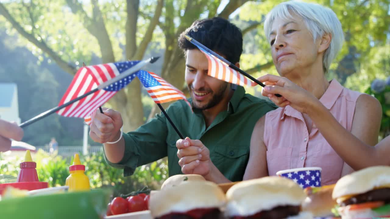 공원에서 식사를 하는 동안 미국  ⁇ 발을 들고 있는 가족 4k