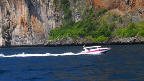 Isla-Phi-Phi-En-Phuket,-Tailandia---Lancha-Rápida-Cruzando-La-Playa-De-La-Isla-Descubriendo-La-Belleza-Natural-De-Los-Acantilados-De-Piedra-Caliza---Tiro-Amplio