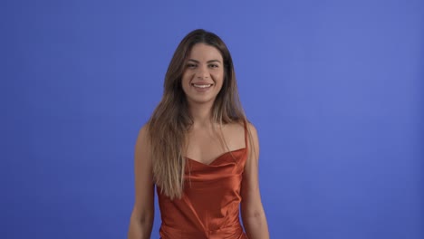 celebration as a pretty young woman is showed in confetti. slow motion, isolated on blue background.