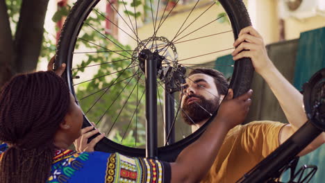 Couple-reattaching-bicycle-wheel-in-yard