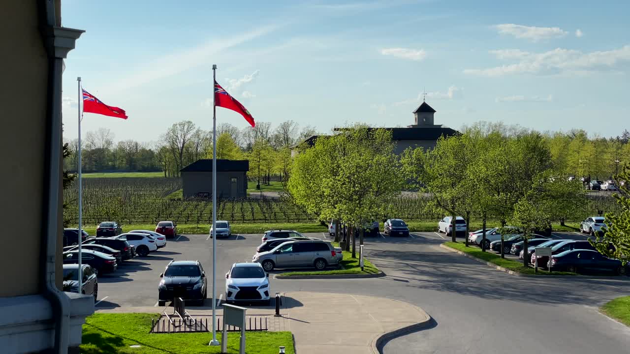 Looking out over a local winery parking lot, Ontario flag waving in slow motion, Canada