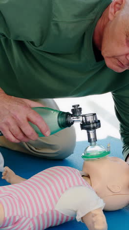 paramédico masculino dando oxígeno a un muñeco