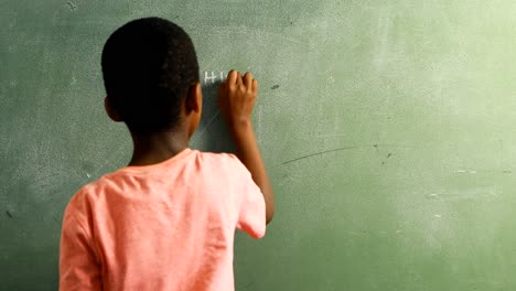 schoolboy doing mathematics on chalkboard in classroom 4k
