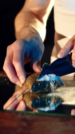 a thug is cutting a package with drugs on the table by knife. drug trafficking. vertical video