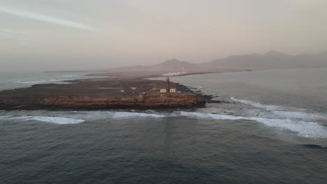 Witness-the-rugged-beauty-of-a-lighthouse-perched-on-a-cliff,-immortalized-in-stunning-drone-imagery—a-picturesque-coastal-landmark-that-commands-attention-and-admiration