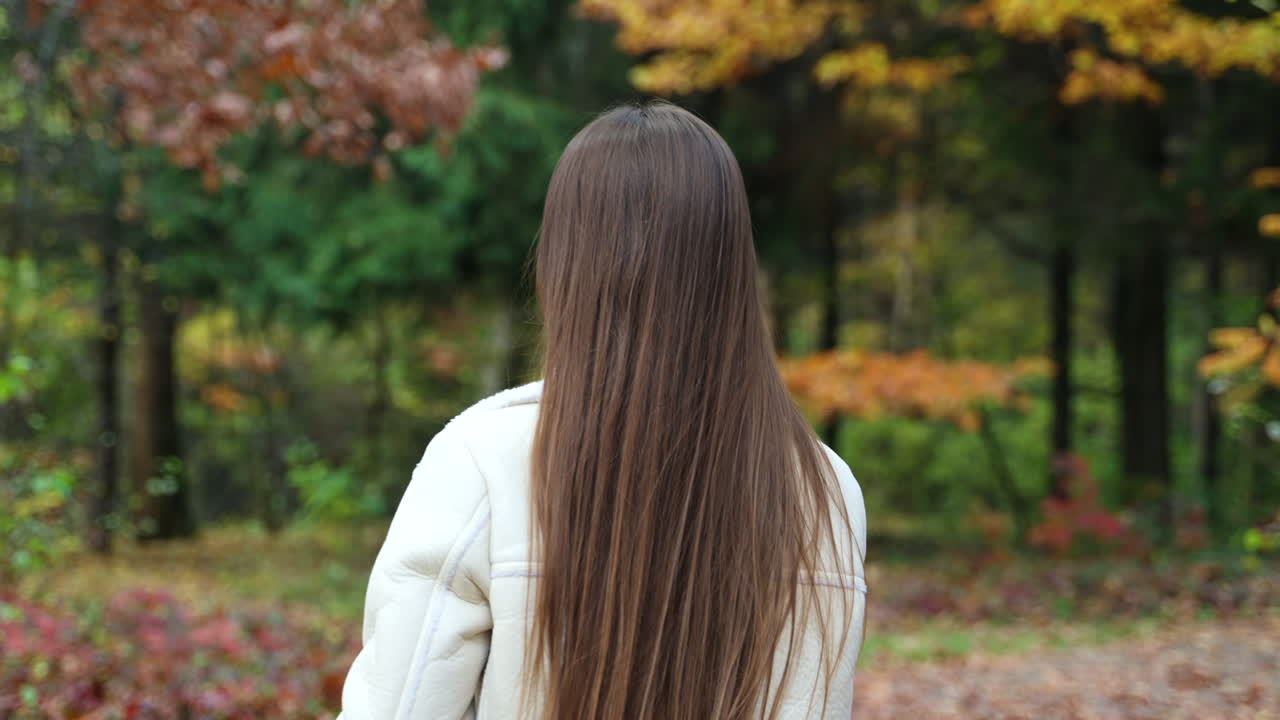 Woman looking at phone in autumn park