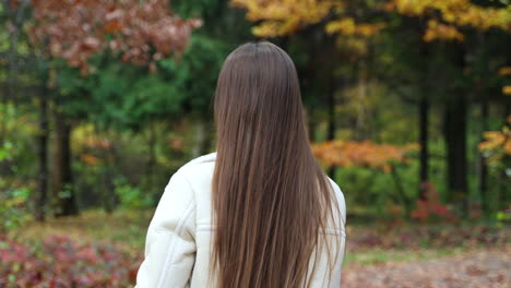 woman looking at phone in autumn park