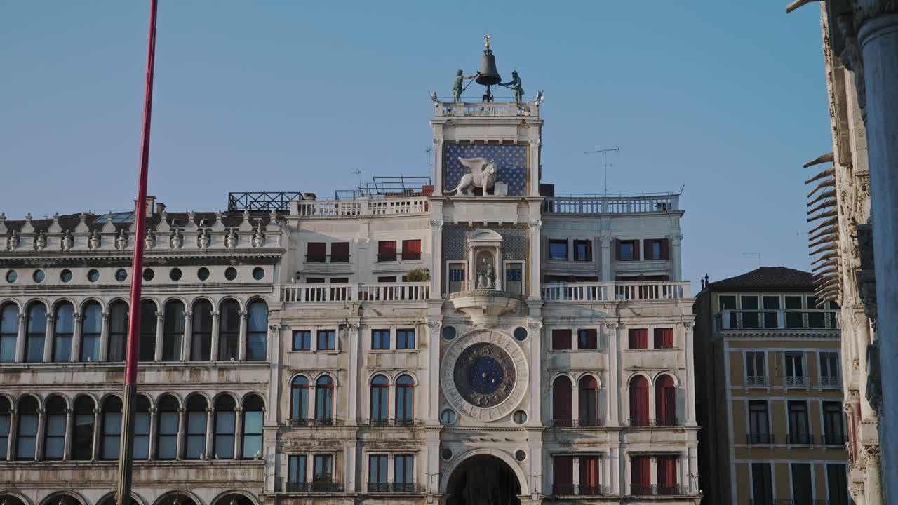 Revealing shot of historical building of St Mark's Astronomical Clock Tower in of Venice, Italy, on a sunny day