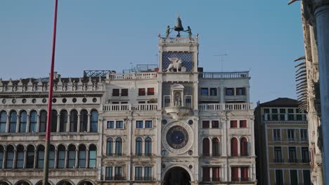 revealing shot of historical building of st mark's astronomical clock tower in of venice, italy, on a sunny day