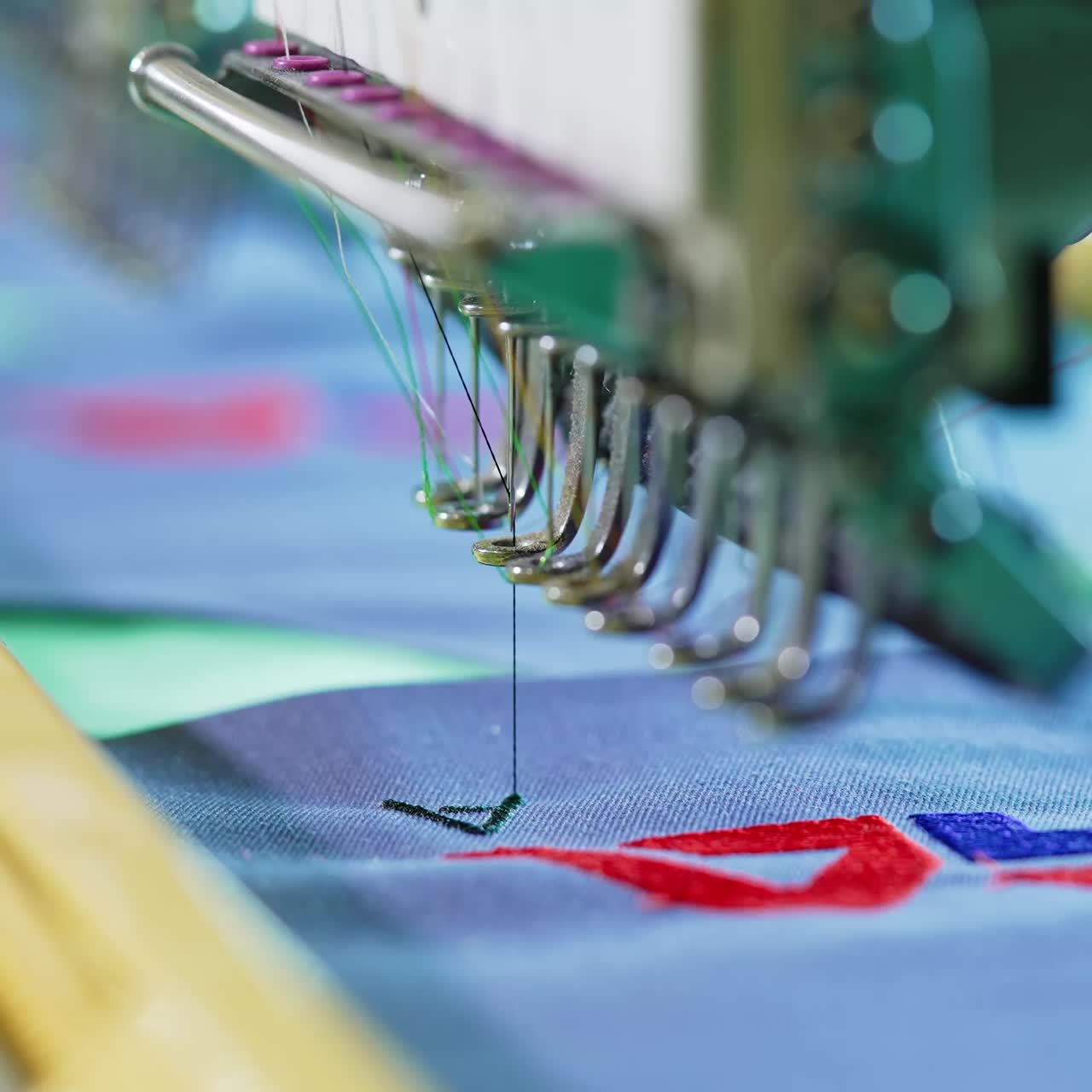 Professional and industrial embroidery machine. Close up of automatic sewing machines at garment factory
