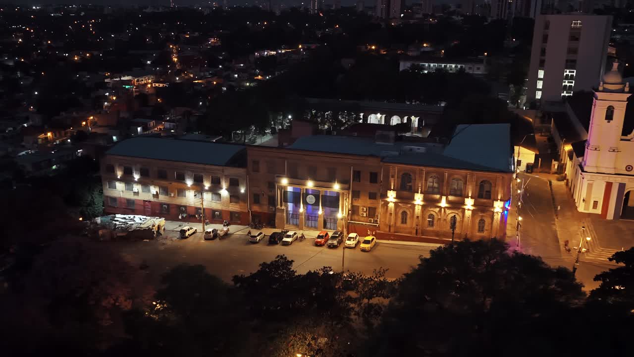 Night aerial view of Centro de Políticas Públicas and Metropolitan Cathedral facade lit with warm lights, Asunción, Paraguay