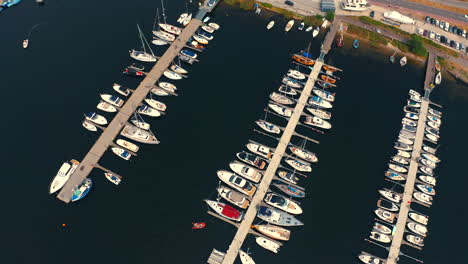 drone flying backwards in the marina in jastarnia, poland with moored luxurious yachts