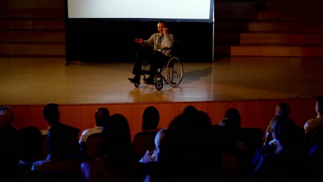 hombre de negocios caucásico maduro discapacitado hablando en un seminario de negocios en el auditorio 4k