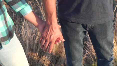 Mujer-Cogida-De-La-Mano-Con-Un-Hombre,-Cámara-Lenta,-Tiro-De-Detalle-Al-Aire-Libre