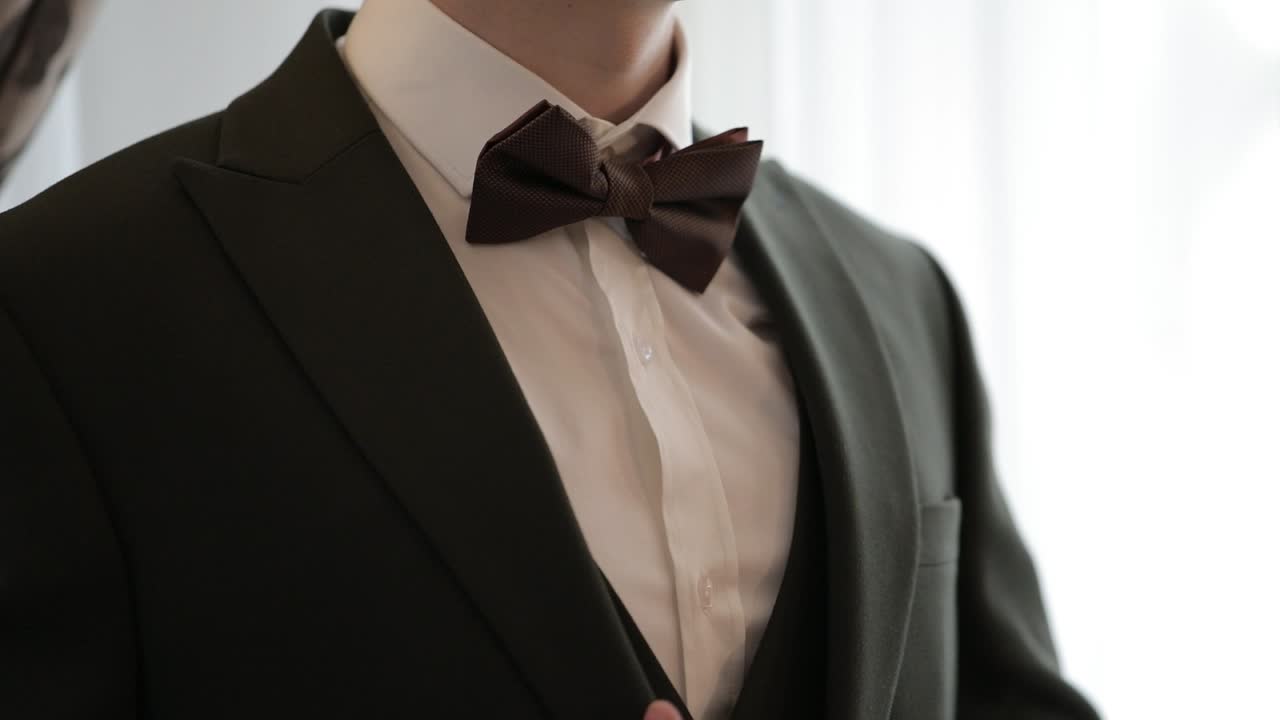 예쁜 세련된 신랑이 초록색 재 ⁇ 을 입고 거실에서 집에, 느린 동작 실내 초상화