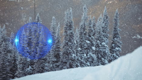 animation of snow falling and blue christmas bauble over winter countryside scenery