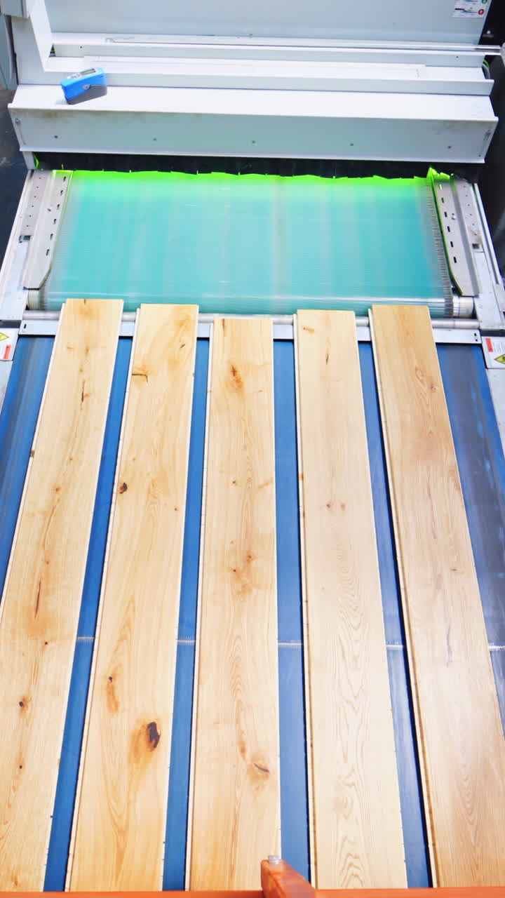 Interior of a laminate production. Top view of wooden boards moving on conveyor line inside the parquet factory. Vertical video