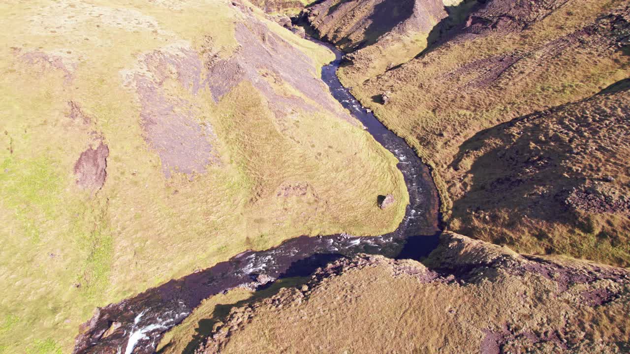 aerial: revelación inversa de la parte superior de la cascada de cola de caballo de kvernufoss y la alcoba oculta donde se puede ir detrás de la cascada