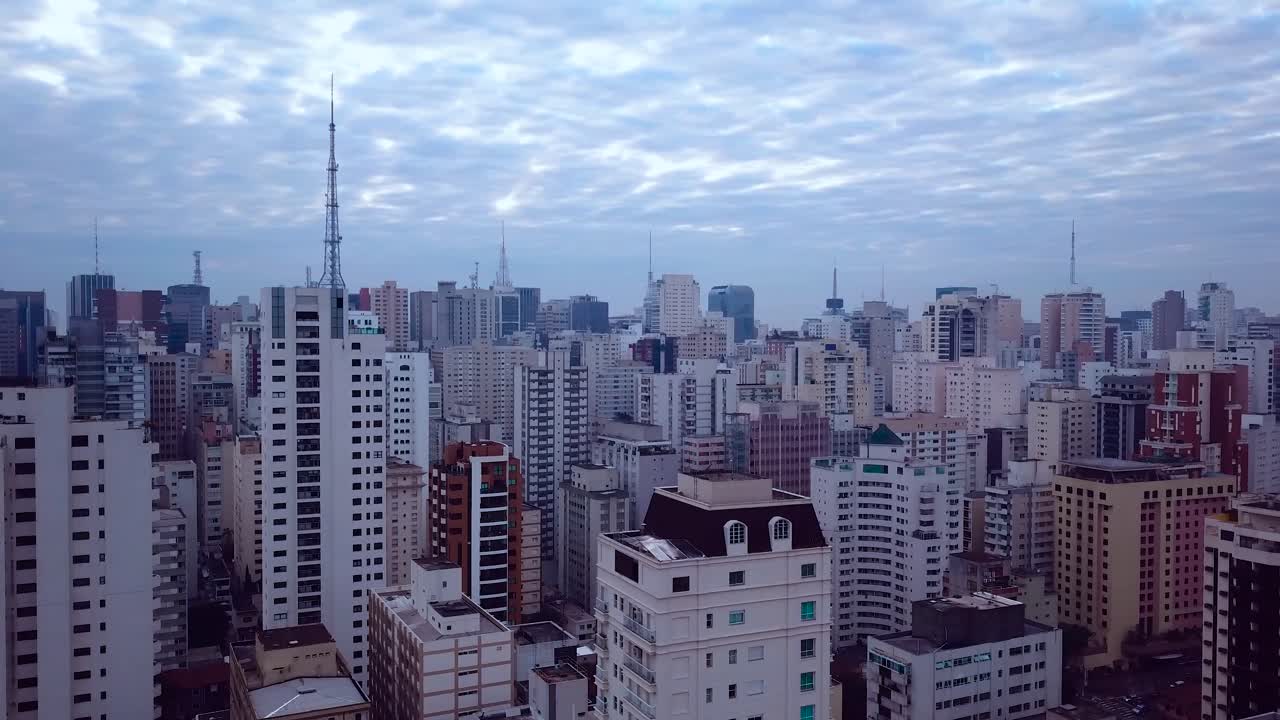 Ripresa aerea panoramica 4K che mostra il centro città di San Paolo al mattino presto e l'Avenida Paulista, con un bellissimo cielo blu.
