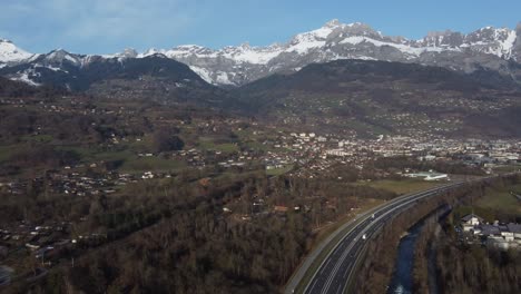 Panorámica-Aérea-Dejada-Sobre-Un-Valle-Verde-Y-Una-Cordillera