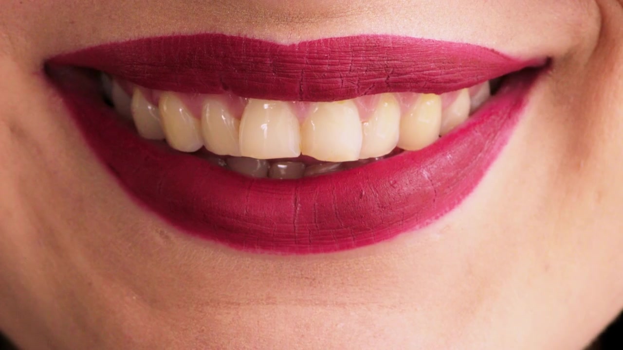 Close-up of a Woman Smiling with Dark Red Lipstick