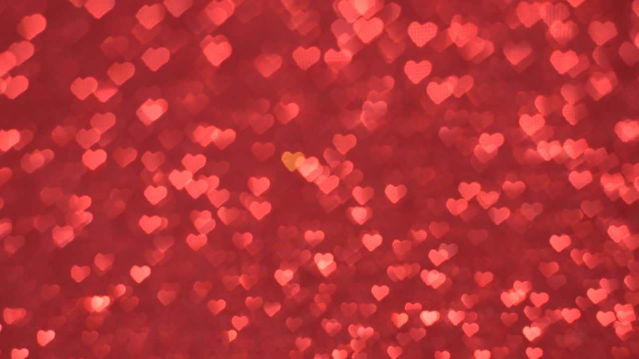 el bokeh en forma de corazón se mueve cíclicamente sobre un fondo rojo.