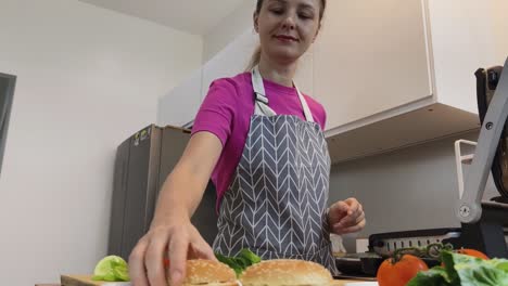 una mujer cocinando una hamburguesa.