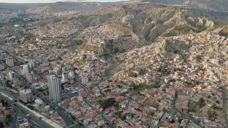 aerial establishing shot of la paz city, bolivia, slum houses on andean mountain with sunlight, latin american travel destination