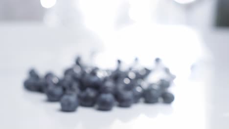 dolly in shot toward fresh blueberries on white table, rack focus, healthy fruit