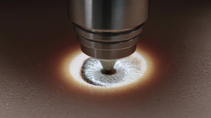 Starting device lowering metal nozzle touching raised skin spot under ring light for lesion care