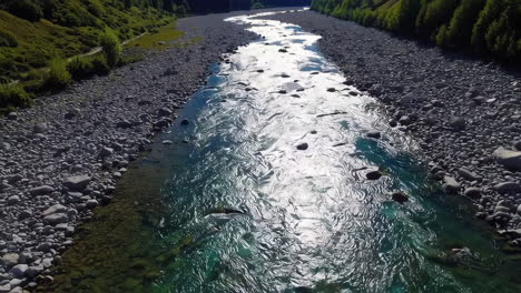 river flowing through a rocky valley with green hills