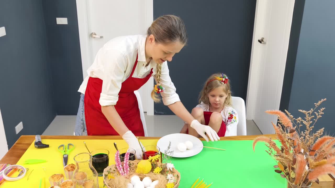 madre e hija teñen huevos de pascua