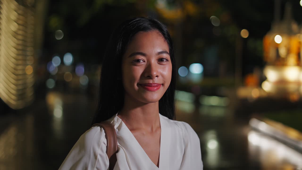Donna sorridente in città di notte