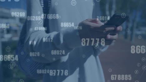 animation of changing numbers and connected icons over midsection of biracial man using cellphone