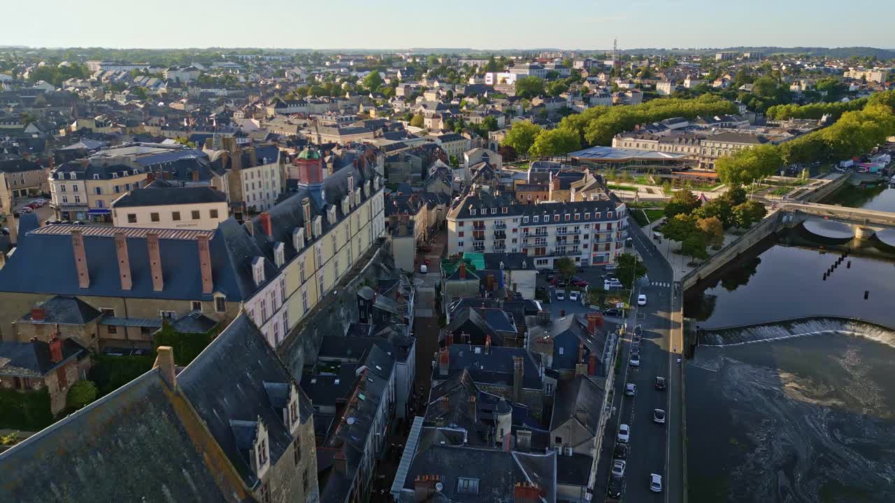 Wide aerial establishing dolly of Chateau de Laval and nearby Chateauneuf with square and streets at sunrise