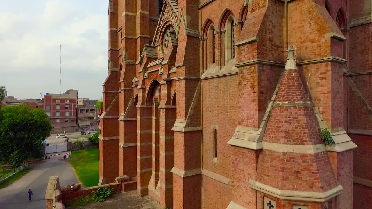 cerrar la vista aérea de una hermosa iglesia antigua, una cruz en el edificio de la iglesia, el tráfico se mueve en el otro lado de la calle de la iglesia
