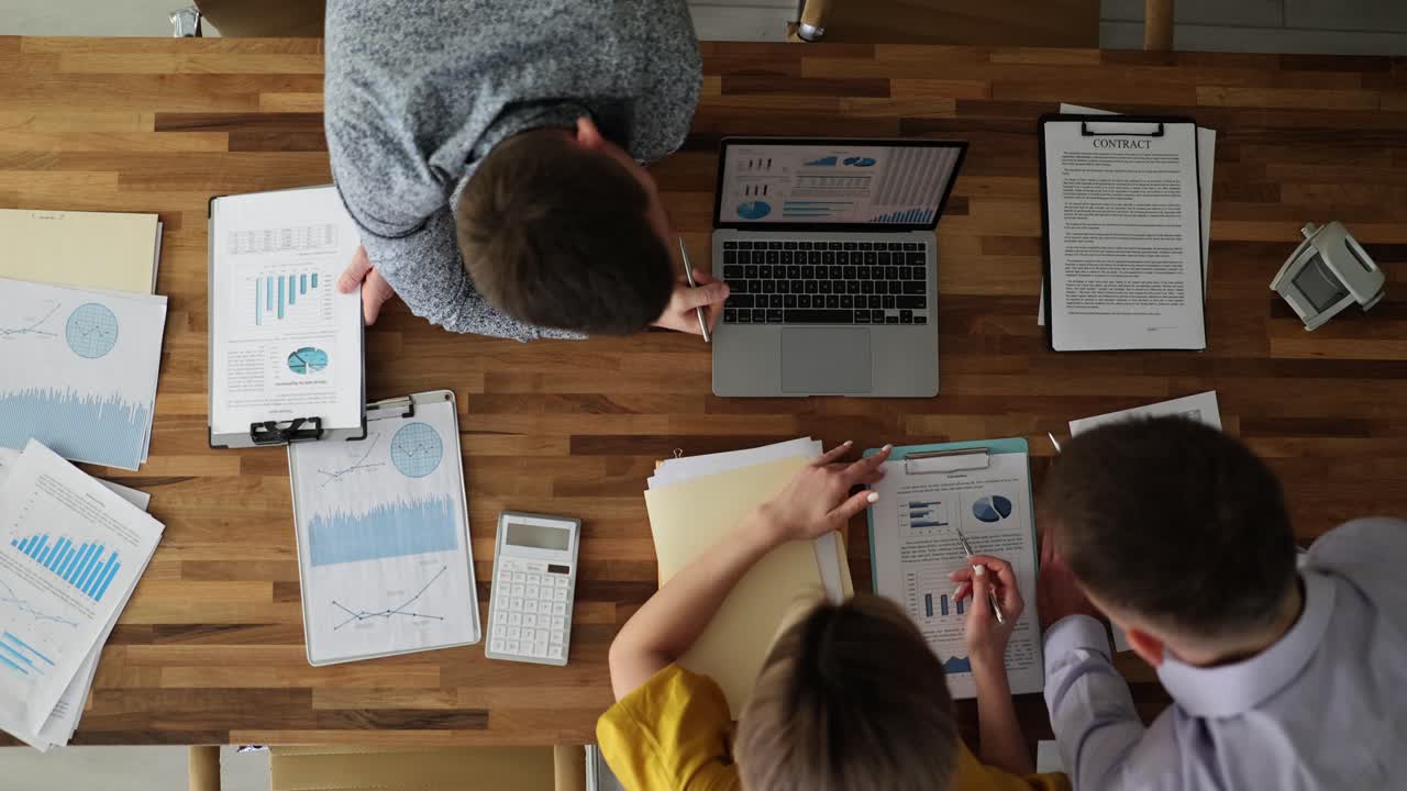 Colleagues team examine information from graphs on laptop