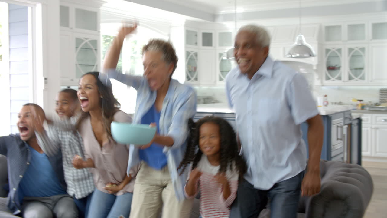 집 에서 tv 에서 스포츠 를 시청 하는 대규모 가족 그룹