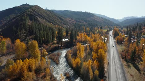 Aerial-view-of-fast-river-by-the-road-in-wilderness-of-Washington,-USA