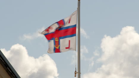 RNLI-flag-fluttering-flying-in-the-wind-at-Calshot-spit,-the-Solent,-Southampton